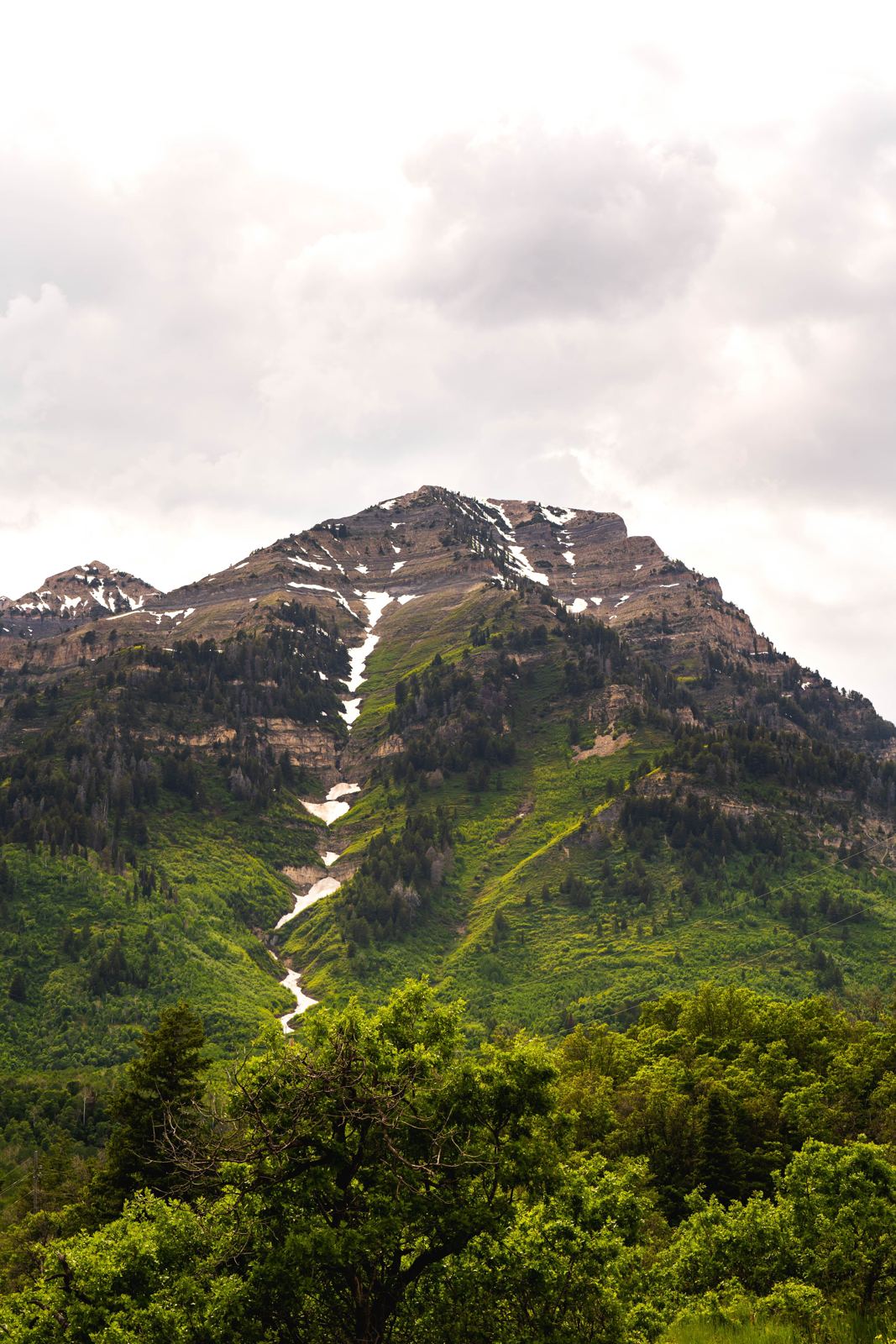 Green mountain peak under a cloudy sky