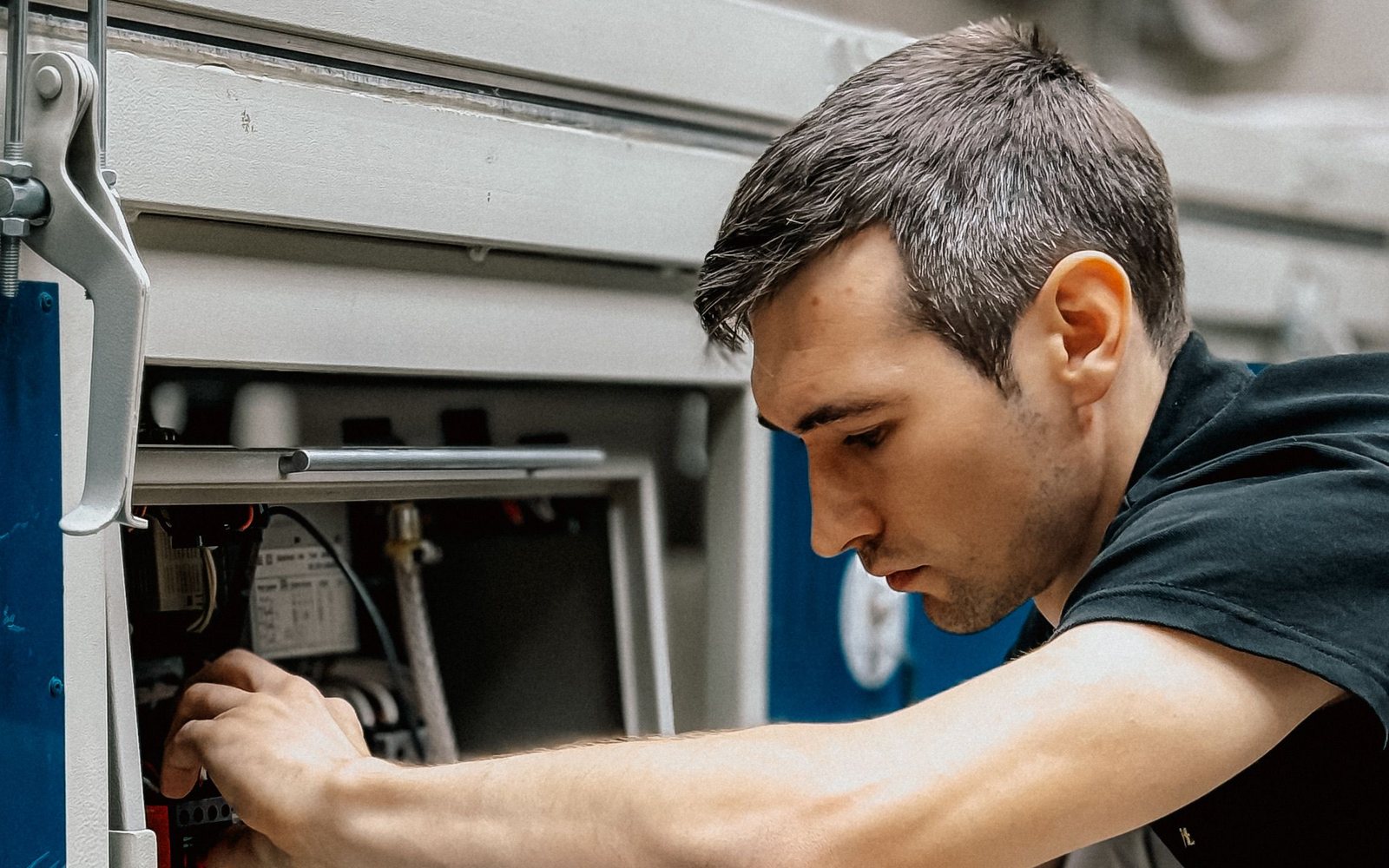 Maintenance technician servicing an equipment control panel